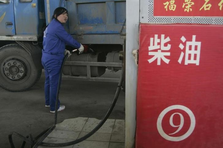 © Reuters. An employee fills the tank of a truck with diesel at a gas station in Taiyuan,