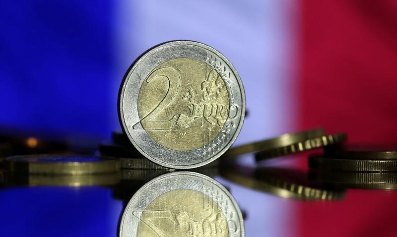 © Reuters. Монеты в 2 евро на фоне флага Франции