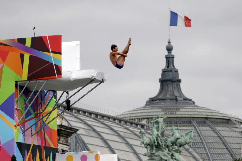 © Reuters. A diver performs from the Pont Alexandre III bridge into the River Seine in Paris