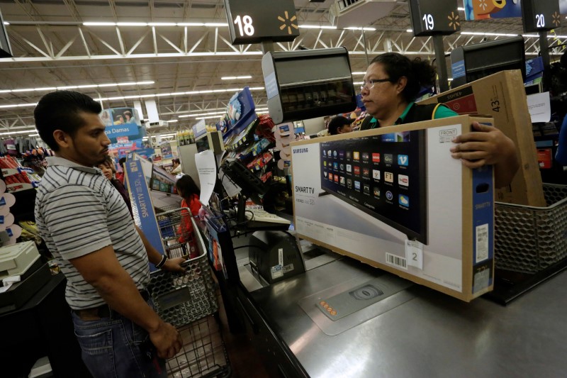 © Reuters. Customer buys a television set during the shopping season, "El Buen Fin", at a Walmart store, in the early hours of Friday, in Monterrey