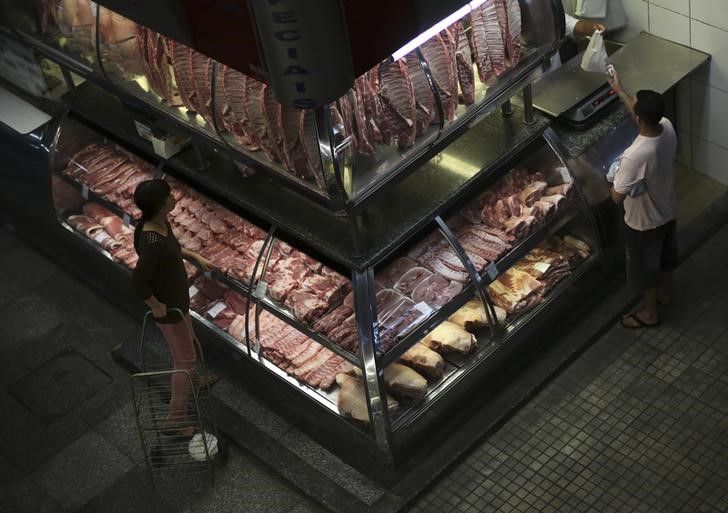 © Reuters. Customer pays for his meat at the Municipal Market in Sao Paulo