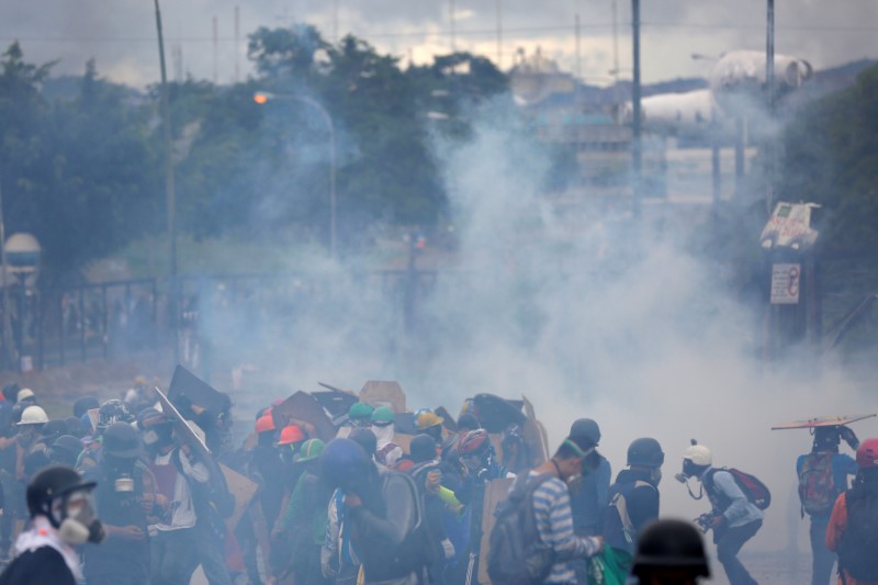 © Reuters. Demonstrators clash with riot security forces while rallying against Venezuelan President Nicolas Maduro's government in front of an Air Force base in Caracas,