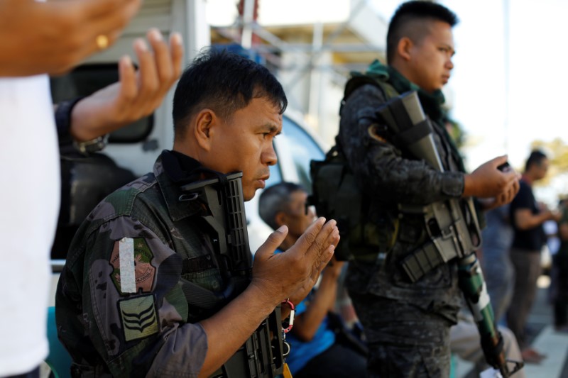 © Reuters. Philippines police officers perform Eid al-Fitr prayers outside a mosque inside city hall compound as government forces continue their assault against insurgents from the Maute group, who have taken over large parts of Marawi City?