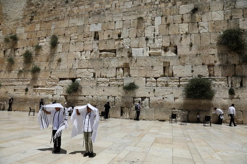 © Reuters. FILE PHOTO: Youth hold their prayer shawls as they stand in front of the Western Wall, Judaism's holiest prayers site in Jerusalem's Old City