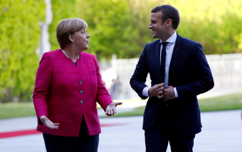 © Reuters. FILE PHOTO: German Chancellor Angela Merkel and French President Emmanuel Macron talk as they arrive at a ceremony at the Chancellery in Berlin