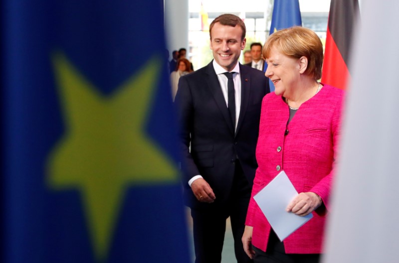 © Reuters. FILE PHOTO: German Chancellor Angela Merkel and French President Emmanuel Macron arrive to a news conference at the Chancellery in Berlin