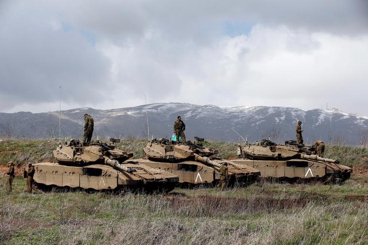 © Reuters. FILE PHOTO: Israeli soldiers stand atop tanks in the Golan Heights near Israel's border with Syria