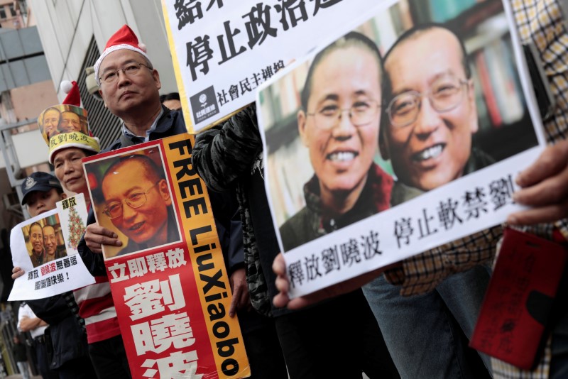 © Reuters. Pro-democracy demonstrators hold up photo of jailed Chinese Nobel Peace Prize laureate Liu Xiaobo during a protest to urge for the release of Liu, outside the Chinese liaison office in Hong Kong
