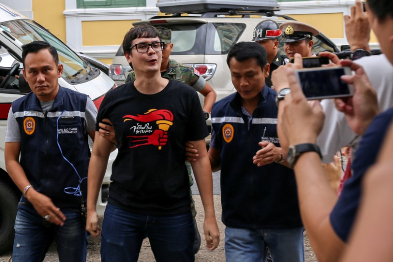 © Reuters. Rome Rangsiman, pro-democracy activist, is escorted by police officers as he arrives at a military court in Bangkok