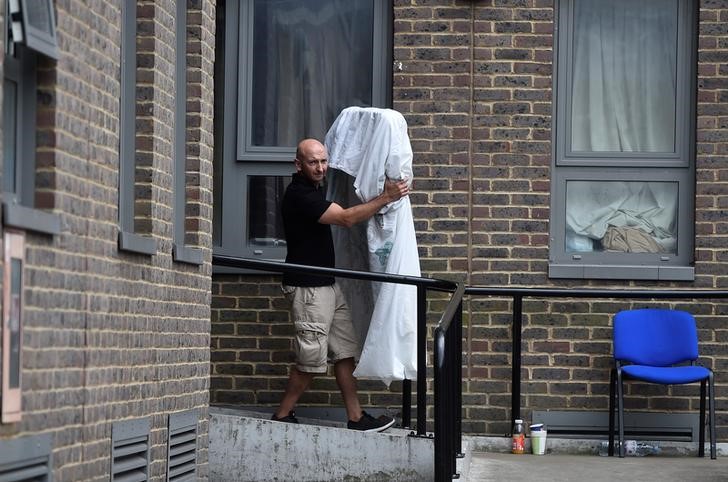 © Reuters. A man carries a mattress from the Dorney Tower residential block, as residents were evacuated as a precautionary measure following concerns over the type of cladding used on the outside of the buildings on the Chalcots Estate in north London