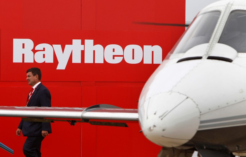 © Reuters. A man walks past a Raytheon logo