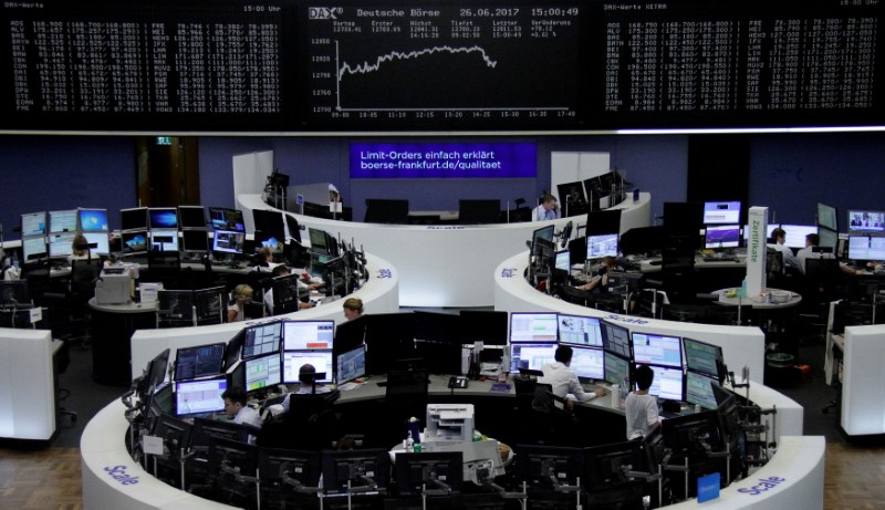 © Reuters. FILE PHOTO: Traders work in front of the German share price index, DAX board, at the stock exchange in Frankfurt