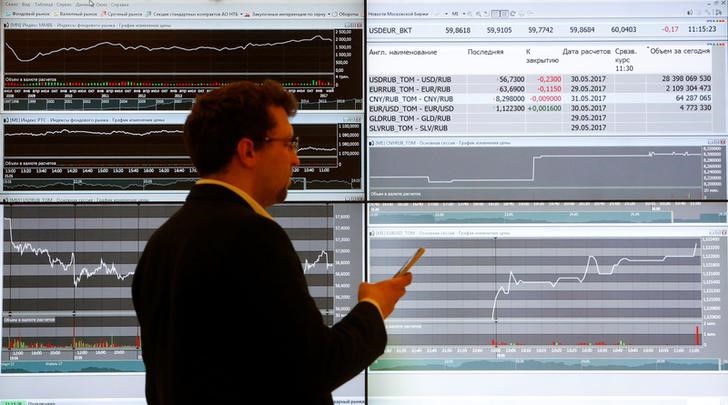© Reuters. Мужчина на фоне экранов с информацией о торгах в помещении Московской биржи
