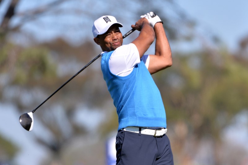 © Reuters. FILE PHOTO: Tiger Woods tees off the 5th hole during the first round of the Farmers Insurance Open golf tournament in La Jolla