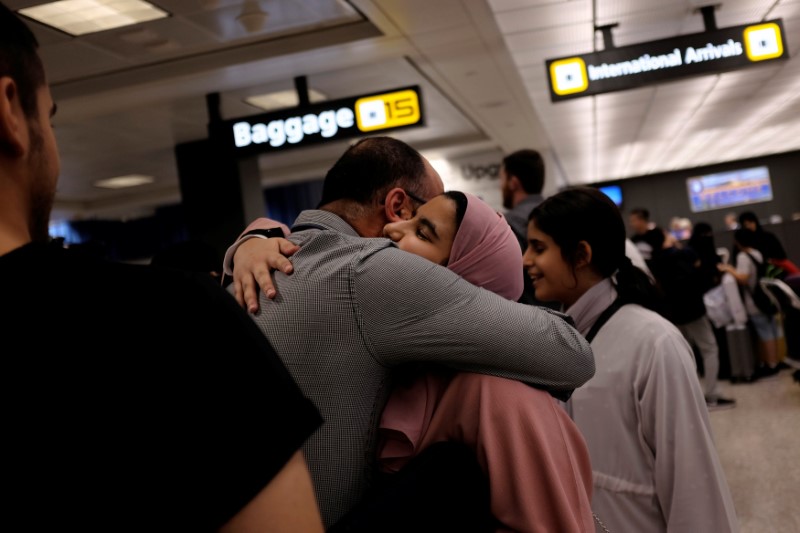 © Reuters. Saudi family embraces as members arrive at Washington Dulles International Airport after U.S. Supreme Court granted parts of the Trump administration's emergency request to put its travel ban into effect later in the week pending further judicial review