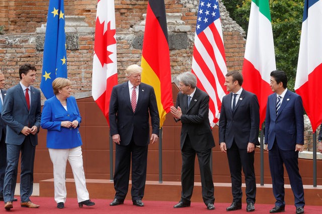 © Reuters. FILE PHOTO: EU President Tusk, Canadian PM Trudeau, German Chancellor Merkel, U.S. President Trump, Italian PM Gentiloni, French President Macron, Japanese PM Abe react during a family photo during the G7 Summit in Taormina