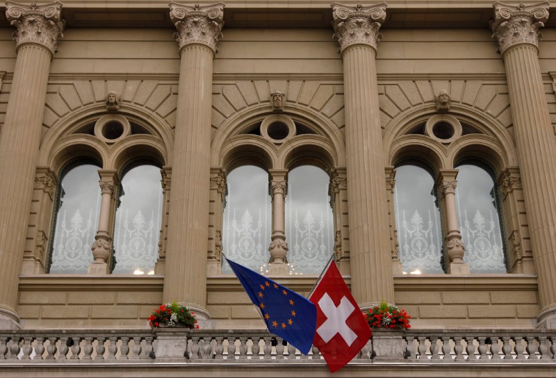 © Reuters. FILE PHOTO: The flags of the European Union and Switzerland flutter in the wind at the Swiss Parliament Building in Bern