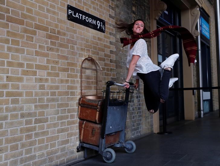 © Reuters. Una mujer posa para una fotografía con el carro de Harry Potter en la estación Kings Cross, en Londres.