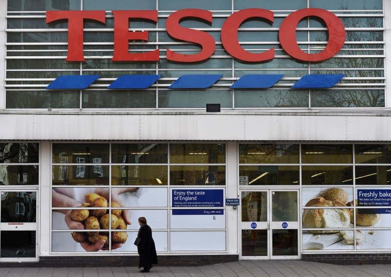 © Reuters. FILE PHOTO: A woman walks past a Tesco supermarket in central London