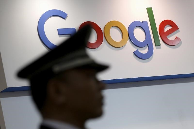 © Reuters. A security guard keeps watch as he walks past a logo of Google in Shanghai
