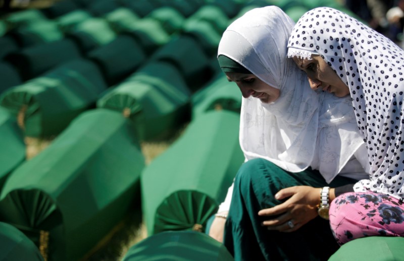 © Reuters. FILE PHOTO: Muslim women cry near coffins of their relatives, who are newly identified victims of the 1995 Srebrenica massacre, which are lined up for a joint burial in Potocari near Srebrenica