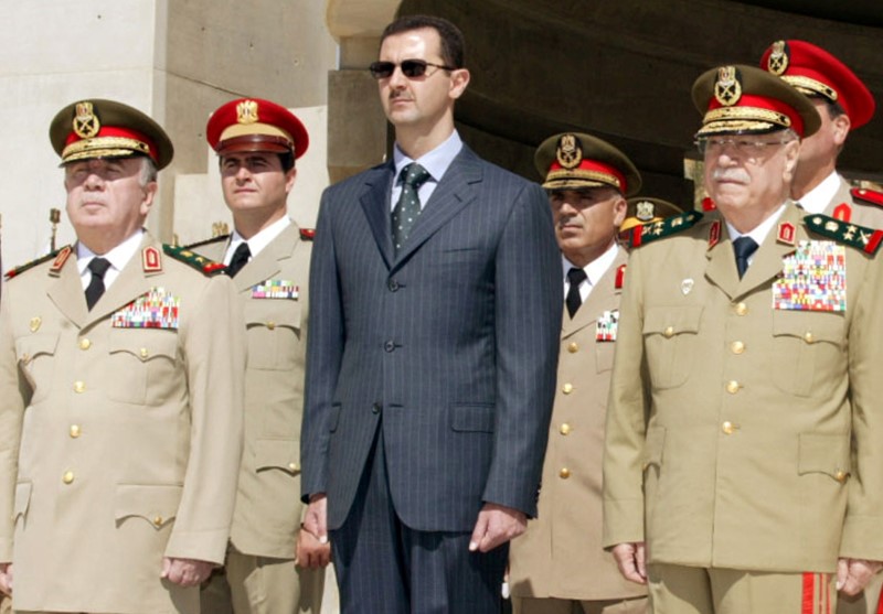 © Reuters. FILE PHOTO: Syrian President Bashar al-Assad, new Defence Minister Hassan Turkmani and former Defence Minister Mustafa Tlass attend a ceremony at the unknown soldier monument in Damascus