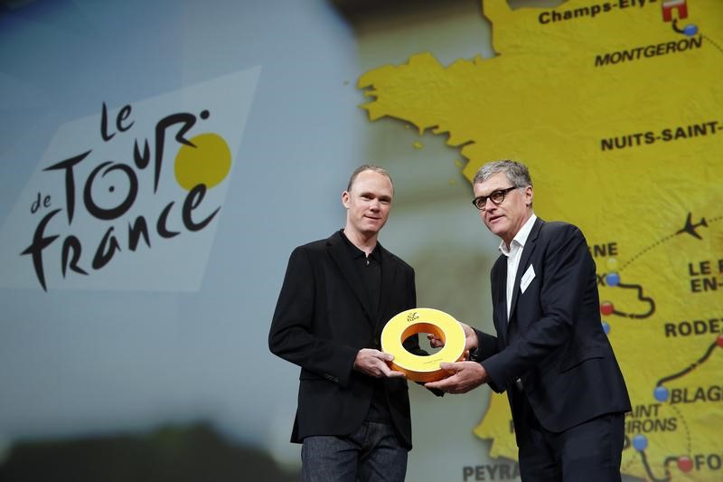 © Reuters. ASO's Laurent Lachaux, Commercial and Marketin Director at Amaury Sport Organisation, presents rider Chris Froome of Britain with a gift after the presentation of the itinerary of the 2017 Tour de France cycling race during a news conference in Paris