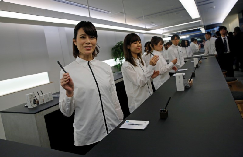 © Reuters. Shop assistants present Japan Tobacco Inc's Ploom Tech smokeless vaping products at its Ploom Shop in Tokyo