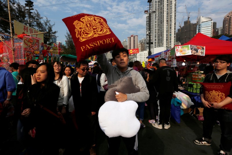 © Reuters. FILE PHOTO: A vendor sells cushions depicting the Apple Inc logo and a British passport inside a Lunar New Year market at Hong Kong's Victoria Park