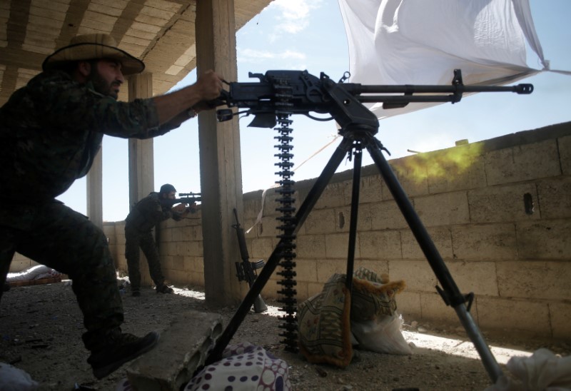 © Reuters. Combatente curdo das Unidades de Proteção Popular (YPG) atira contra militantes do Estado Islâmico, na Síria