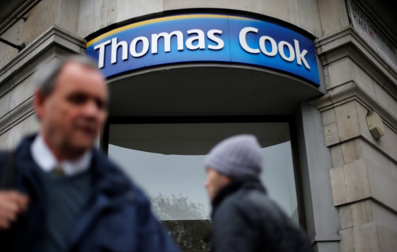 © Reuters. FILE PHOTO: Pedestrians walk past a Thomas Cook shop in central London