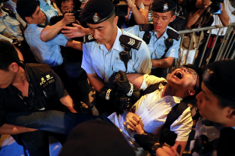 © Reuters. Manifestante é carregado por policiais em Hong Kong antes de celebração de transferência da cidade dos britânicos para os chineses, na China