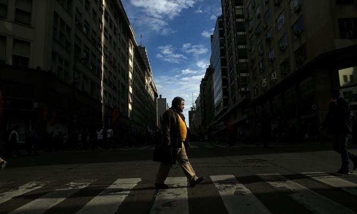 © Reuters. A man crosses the street in Buenos Aires' financial district