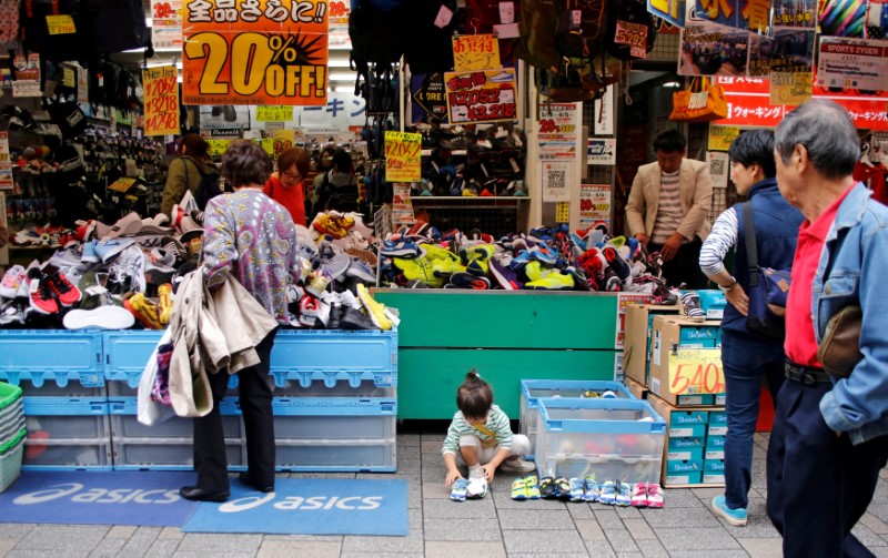 © Reuters. FILE PHOTO: A child reaches for a pair of shoes at a shoe store on a shopping street in Tokyo