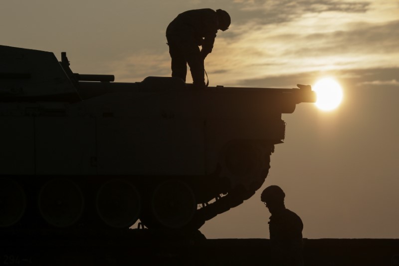 © Reuters. US soldiers prepare a M1 Abrams tank to offload from a train at the Mihail Kogalniceanu Air Base