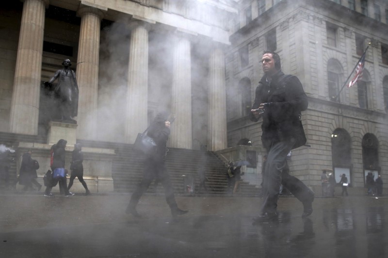 © Reuters. Morning commuters walk through a steam cloud on Wall St. during a morning snow fall in New York's financial district