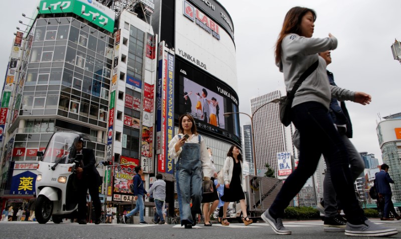 © Reuters. FILE PHOTO: People cross a street in the Shinjuku shopping and business district in Tokyo