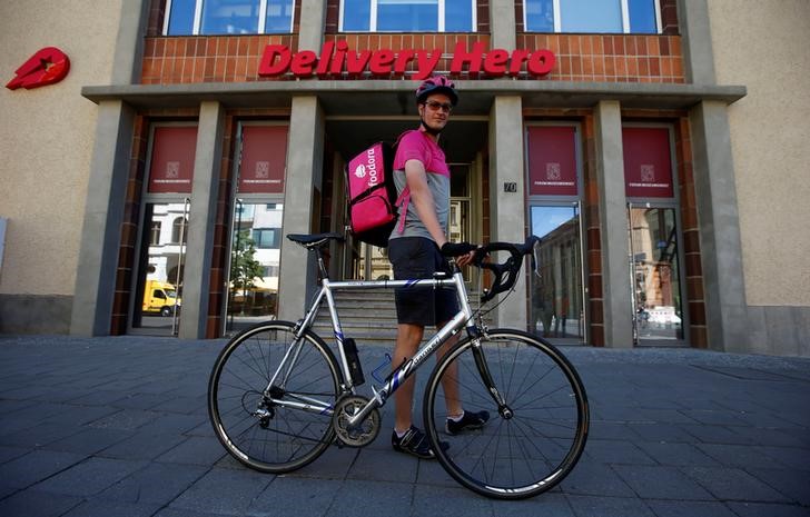 © Reuters. A Foodora delivery cyclist poses in front of Delivery Hero headquarters in Berlin