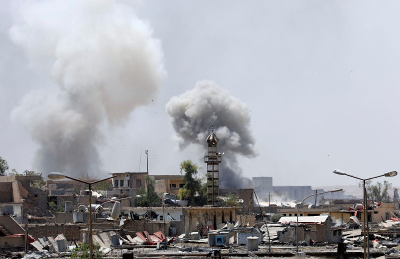 © Reuters. El humo se agita en las posiciones de los militantes islámicos después de un ataque de artillería de los soldados iraquíes en el oeste de Mosul.