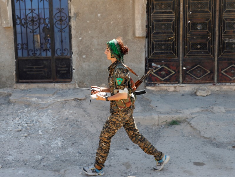 © Reuters. Sheen Ibrahim, Kurdish fighter from the People's Protection Units (YPG) walks in Raqqa