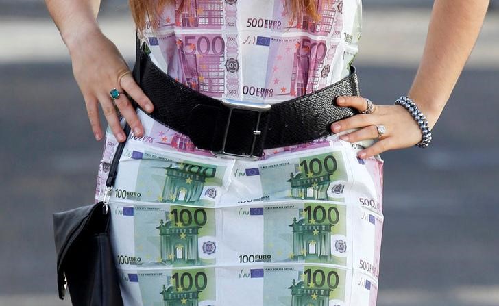 © Reuters. FILE PHOTO: FILE PHOTO: A woman wears a home-made dress featuring imitation 100 and 500 euro notes as she walks in Bordeaux