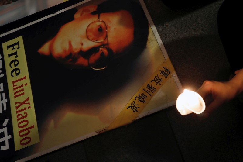 © Reuters. A protester holds a candle next to a portrait of Chinese Nobel rights activist Liu Xiaobo demanding his release, during Chinese President Xi Jinping visiting, ahead of 20th anniversary of the city's handover from British to Chinese rule, in Hong Kong