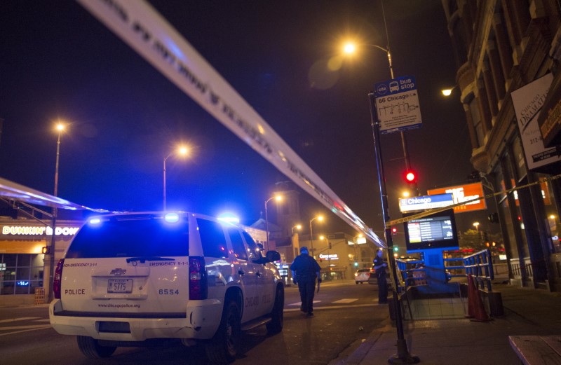 © Reuters. Chicago police officer investigate a crime scene of a gunshot victim in Chicago