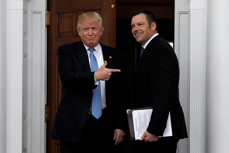 © Reuters. FILE PHOTO: U.S. President-elect Trump stands with Kansas Secretary of State  Kobach before their meeting at Trump National Golf Club in Bedminster