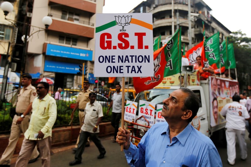 © Reuters. A supporter of India's ruling Bharatiya Janata Party holds a placard during a rally to support implementation of GST in Mumbai