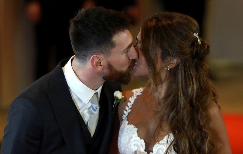 © Reuters. El futbolista argentino Lionel Messi y su esposa Antonela Roccuzzo se besan al posar para una fotografía luego de su matrimonio en Rosario, Argentina