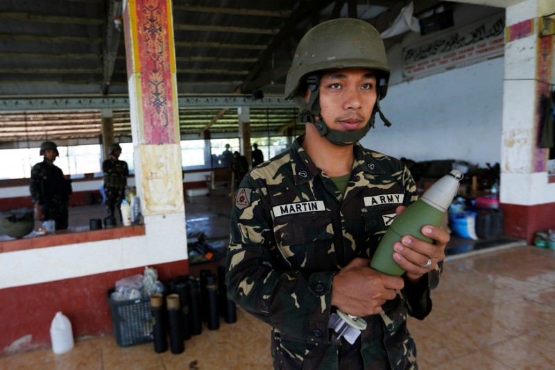 © Reuters. A Filipino soldier prepares to launch a mortar from their combat position as government troops continue their assault against insurgents from the Maute group in Marawi city