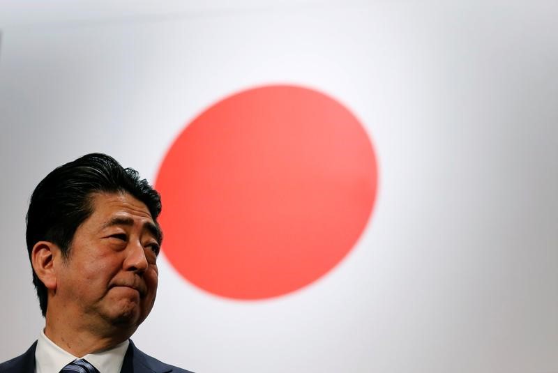 © Reuters. Japan's Prime Minister Abe stands in front of Japan's national flag after his ruling LDP annual party convention in Tokyo