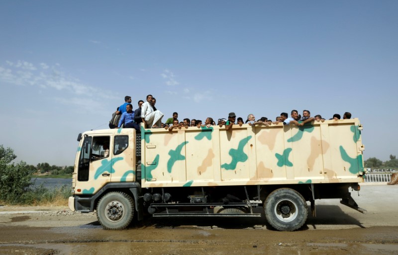 © Reuters. Displaced Iraqi civilians are transported in an army truck after being liberated from scene of battle in the Old City in Mosul