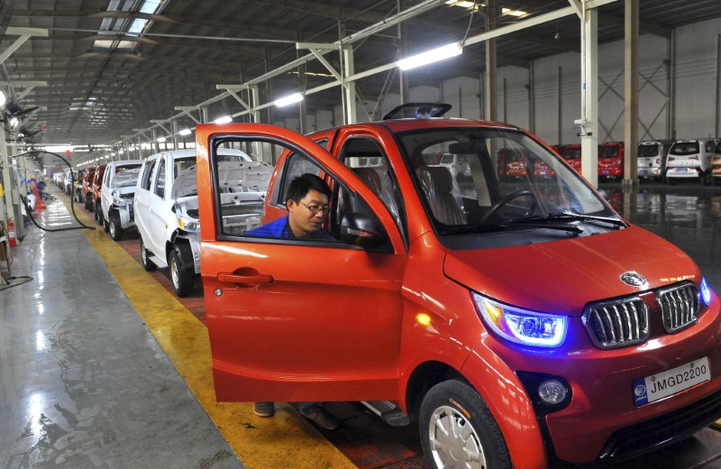 © Reuters. An employee assembles an electric car along a production line at a factory in Qingzhou